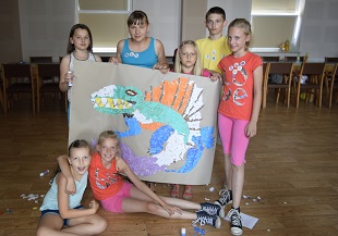 dzieci z pracą przedstawiającą dinozaura