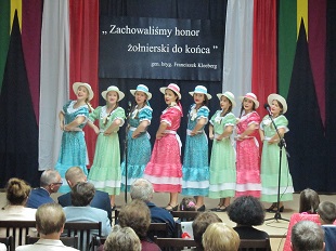 grupa dziewcząt śpiewa piosenkę na scenie