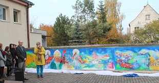 grupa osób przed muralem